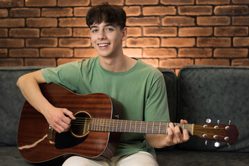 Young smiling man playing guitar