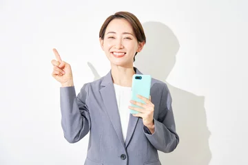 Zelfklevend Fotobehang スマートフォンを持って左を指差すビジネスウーマン　白背景 © siro46