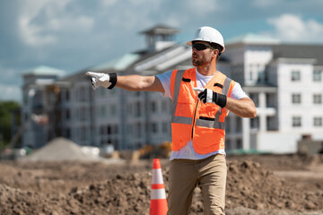 Construction site worker in helmet working outdoor. A builder in a safety hard hat at constructing...