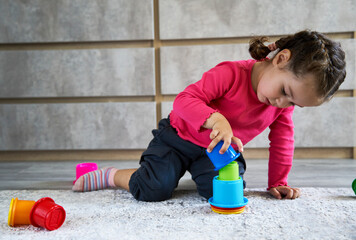 Cute child playing colorful pyramid