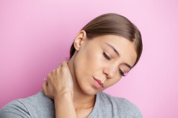 Young woman feeling exhausted and suffering from neck pain, health concept.