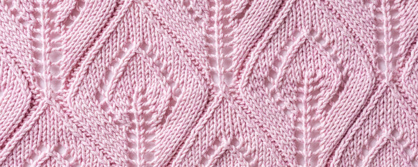 Banner with handmade pink knitting wool texture background with knitted leaf shapes. Top view of knitting clothes