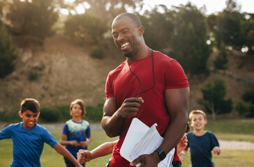 Obraz premium Coach having a fun training session with kids in a school