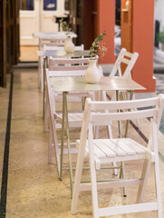 Line of white chairs and tables for 2