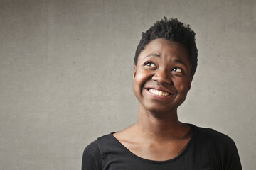 portrait of young woman with thinking expression on gray background
