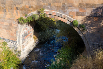 Medieval bridge over Azat river on sunny summer day. Garni gorge, Armenia.