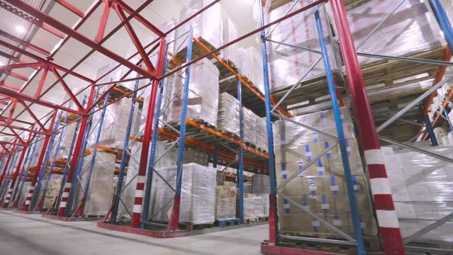The camera moves through the factory warehouse. Modern warehouse, industrial interior. Large modern warehouse with goods without people.