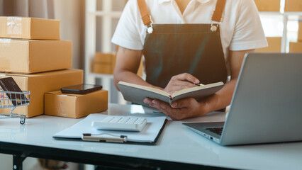 Asian business man seller freelancer prepares box for delivery to  customer in sme supply chain, warehouse.