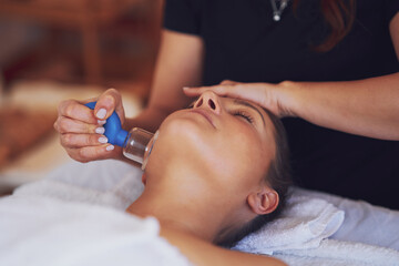Obraz na płótnie Canvas Woman having a face cupping massage in salon