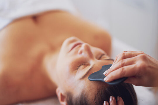 Brunette woman having a stone massage on face