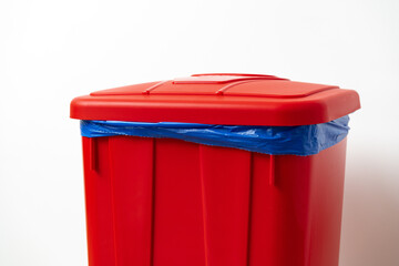 Plastic waste bin with a lid in the room