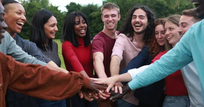 Young multiracial people stacking hands outdoor