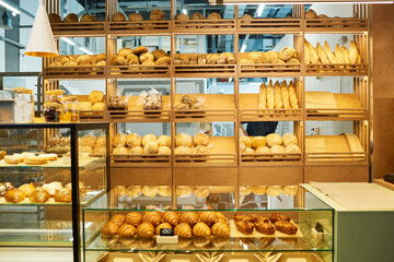 Counter desk of bakery clerk and displays with fresh bread and pastry assortment being sold in cafeteria after cooking by professional baker