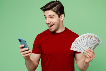 Young man he wears red t-shirt casual clothes hold in hand fan of cash money in dollar banknotes...