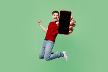 Full body young man wear red t-shirt casual clothes jump high hold in hand use close up mobile cell...