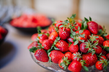 Fresh ripe and tasty strawberries in a glass bowl on table soft focus