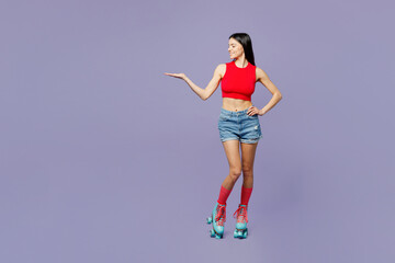 Fototapeta na wymiar Full body happy young latin woman she wear red casual clothes rollers rollerblading point empty hand aside on area isolated on plain pastel purple background. Summer sport lifestyle leisure concept.