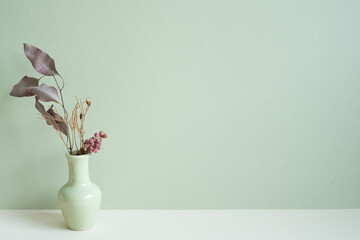 Vase of dry flower on white table. mint wall background. copy space