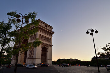 Paris, France. Moon and Arc de Triomphe at sunset. July 3, 2022.