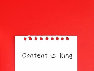 note paper on red copy space background with handwritten text CONTENT IS KING, to indicate Internet as a marketplace for content. Content has the power for branding and attract users engagement