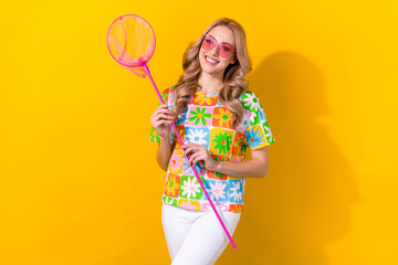 Portrait of cute adorable woman with wavy hairdo wear flower print t-shirt hold net for butterflies isolated on yellow color background