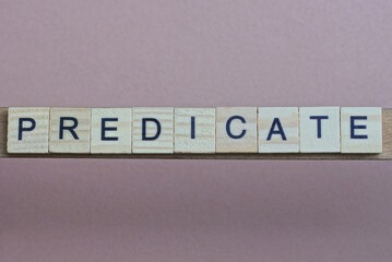 gray word predicate made of wooden square letters on brown background