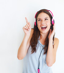 Fototapeta premium Music headphones, pointing and happy woman listening to girl song, audio podcast or radio sound. Mockup gesture, studio freedom and excited model streaming edm playlist isolated on white background