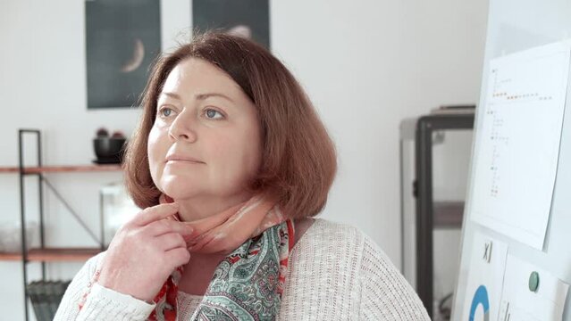 Motivational footage. Portrait of a successful adult plump woman thinking and smiling against the backdrop of an informal office and a whiteboard. Small family business. Business training