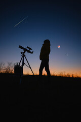 Astronomer looking at the starry skies, planets, meteor shower and lunar eclipse with a telescope.