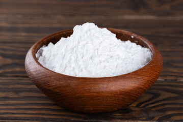 Fototapeta na wymiar Powdered tapioca starch in a wooden bowl, dry cassava root.