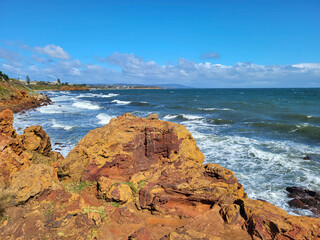View from the boardwalk at Mornington overlooking Port Phillip Bay with rough seas and blue skies.