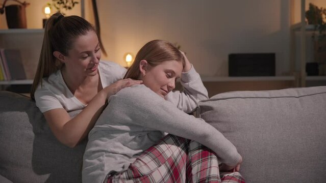Young woman comforting sad sister and making her smile. Depression and loss concept.