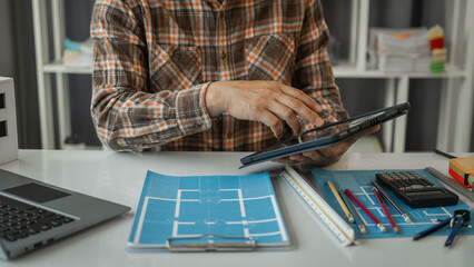 Architecture Interior designer working with building apartment plans blueprints on desk table at...