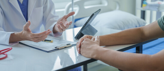 Male doctor is consulting with a young man about prostate cancer and venereal disease and sexual dysfunction about the causes of erectile dysfunction in an examination room.