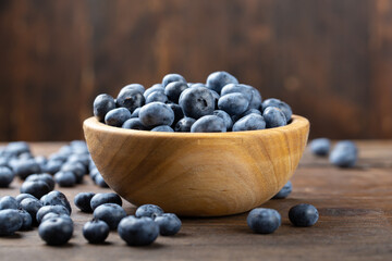Fresh blueberry in wooden bowl. Concept of healthy and dieting eating.