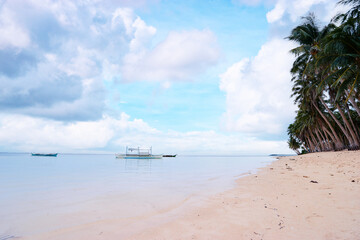 Beautiful landscape - tropical white sand beach with fishing boats. Siargao Island, Philippines.