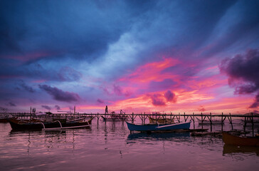 Beautiful colorful sunset on the seashore with fishing boats. Philippines, Siargao Island.