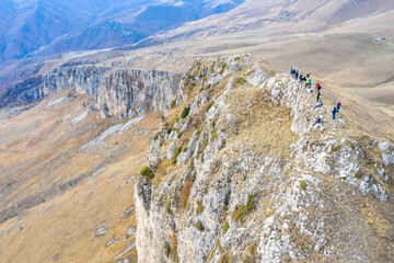 Aerial view of group of tourists on Mount Dimats summit on cloudy autumn day. Dilijan National Park, Tavush Province, Armenia.