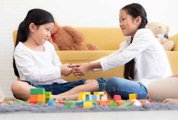 Naughty girl play block game and snatch toy from her sister. Asian kids have fun family leisure...