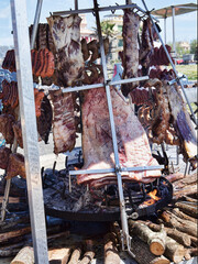 Street food with huge barbecue with many cuts of traditional Argentina wood-fired cow and pork meat on the spit
