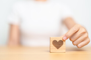 Hand holding heart block for health care, love, organ donation, charity, happy family, wellbeing and insurance concepts. world heart day, health day and mental health day