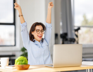 Joyful   business woman freelancer  entrepreneur smiling and rejoices in victory while sitting at...