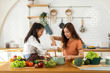 Portrait of enjoy happy love asian family mother with little asian girl daughter child help cooking...