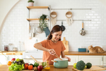 Portrait of beauty body slim healthy asian woman having fun cooking and preparing cooking vegan food healthy eat with fresh vegetable salad in kitchen at home.Diet concept.Fitness and healthy food