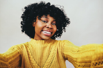 cheerful Black woman taking a selfie smiling with open mouth looking at camera