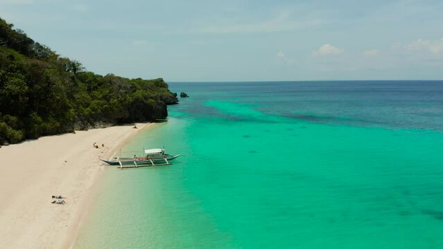 Tropical white sand beach, near the blue lagoon and corall reef from above, Boracay, Philippines. Sandy beach with tourists. Summer and travel vacation concept.
