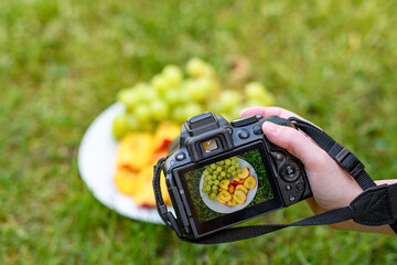 Talerz pełen owoców winogron i nektarynki fotografowany aparatem fotograficznym z podglądem na...