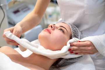 Obraz na płótnie Canvas Beautiful young woman getting a face treatment at beauty salon.