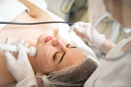 High angle view of beautiful young woman having Radio frequency skin tightening treatment in beauty clinic