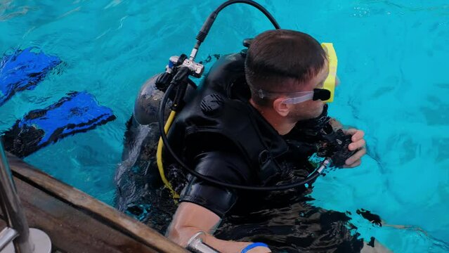 a man with scuba diving is sitting on board a yacht, preparing to dive, diving in the sea, an instructor teaches how to scuba dive, the process of learning to dive.